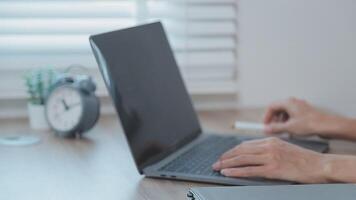 Closeup image of a business woman's hands working and typing on laptop keyboard on glass table video