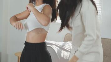 Lycklig asiatisk generation z kvinna vänner vlogger influencer innehåll skapare njut av och roligt använder sig av smartphone uppkopplad leva strömning viral video omslag dansa på social media Ansökan i sovrum på Hem.