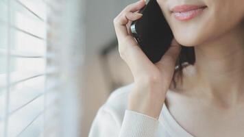 Smiling businesswoman using phone in office. Small business entrepreneur looking at her mobile phone and smiling. video