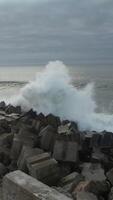 verticaal video van zee golven crashen in de pier antenne visie