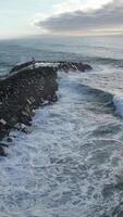 vertical vídeo do mar ondas falhando dentro a cais aéreo Visão video