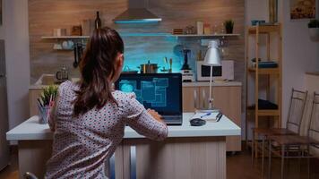 Woman scrolling programming security hacking code data late at night on laptop. Programmer writing a dangerous malware for cyber attacks using performance device during midnight. photo