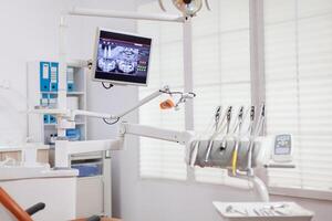 Dental instruments and tools in a dentist office. Stomatology cabinet with nobody in it and orange equipment for oral treatment. photo