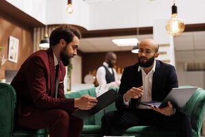 Business professionals gather at hotel for international conference, united by their shared passion for global economic growth. Employee travelling on business trip to meet partner. photo