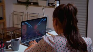 Female gamer playing video game in midnight from home using professional laptop. Professional player testing online video games on her personal computer with modern technology network wireless. photo