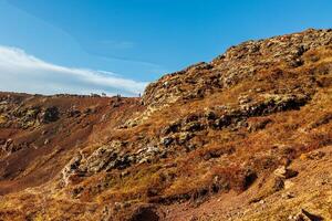 Massive steep mountain cliffs in highlands of Iceland, rock formations creating gorgeous slopes along icelandic valley. Wilderness on northern shoreline created by rocky hills. photo