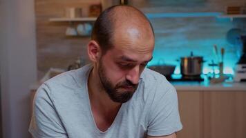 Stressed man working overtime feels eye fatigue after computer work late at night. Portrait of busy focused employee using modern technology network wireless doing overtime for job reading typing photo