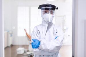 Tired doctor during global outbreak because of population infection with coronavirus. Medical personal dressed in protection equipment against infection with covid-19 during global pandemic. photo