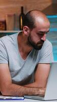 Entrepreneur sitting in remotely office working on laptop computer holding head with hands looking down. Busy focused employee using modern technology network wireless doing overtime for job reading photo