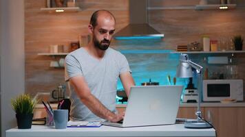 Overwork remote manager tired late hour job program looking astonished at watch. Busy focused employee using modern technology network wireless doing overtime for job reading writing, searching photo