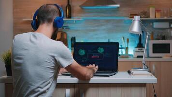 Male hacker failing in coding a dangerous virus to attack company database, angrily shutting down the laptop. Programmer writing a malware for cyber attacks using performance device during midnight. photo