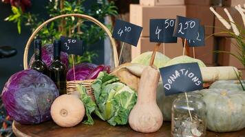 Variety of fresh locally grown lettuce and cabbage next to donations jar, colorful ripe natural products on farmers market stand. Organic produce on counter and table with coins. Close up. photo