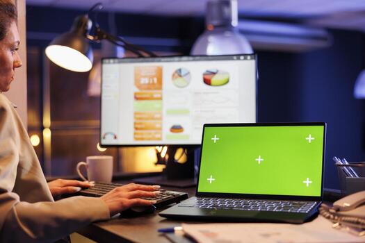 ejecutivo gerente mecanografía márketing estrategia mientras analizando con verde pantalla croma llave burlarse de arriba ordenador portátil computadora con aislado mostrar. joven mujer de negocios trabajando horas más de a inversión plan foto