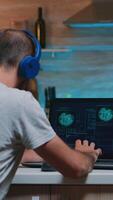 Man hacker with headset coding html and programming on screen laptop working from home in midnight. Programmer writing a dangerous malware for cyber attacks using performance device late at night photo