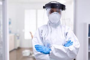 Physician wearing face shield and hazmat suit agasint contamination with coroanvirus. Medical personal dressed in protection equipment against infection with covid-19 during global pandemic. photo