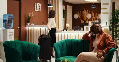 Businesswoman travelling for work waiting in front of reception desk for her room reservation check in process to be done by teamworking hotel staff. Visitor being booked in by helpful asian receptionist photo