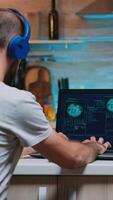 Back view of hacker with headset attacking succesfully the government using finetech, working from home in midnight. Programmer writing a dangerous malware for cyber attacks using performance device photo