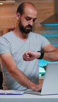 Businessman checking hour and closing pc working remotely from home late at night. Busy focused employee using modern technology network wireless doing overtime for job reading writing, searching photo