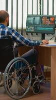 Team of videographers working at video project creating content, man blogger sitting in wheelchair in modern company office. Disabled freelancer editing footage postproduction in studio. photo