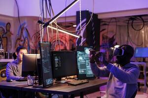 Criminal hacking using vr technology and breaking into server while exploring metaverse. Hacker in virtual reality headset doing illegal activity and programming malicious software photo