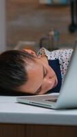 Exhausted overload business woman falling asleep on desk with open laptop monitor while working from home. Busy employee using modern technology network wireless doing overtime sleeping on table. photo