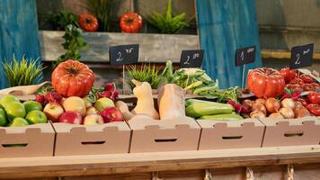 Boxes filled with organic fruits and vegetables placed on stand, fresh natural farming produce at outdoors food fair. Empty local farmers market counter with raw colorful healthy products. photo