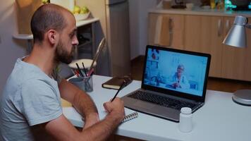 médico explicando diagnóstico durante un vídeo conferencia y paciente escritura en cuaderno. médico dando consulta a enfermo paciente desde hospital oficina durante virtual examen trabajando con el tiempo. foto