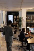 Business team discussing marketing statistics during online videocall meeting conference, working over time at company strategy in startup office. Remote coworkers preparing investment graph photo