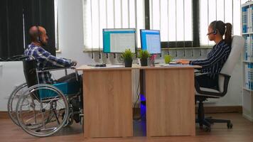 Paralysed businessman in wheelchair using headset making telemarketing and offering customer support. Immobilized disabled freelancer working in financial corporate building using modern technology photo