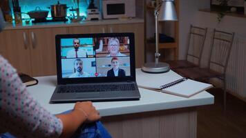 mujer hablando con compañeros de trabajo durante vídeo conferencia a medianoche desde hogar participación un taza de café. dama utilizando moderno tecnología red inalámbrico hablando en virtual reunión a medianoche haciendo tiempo extraordinario foto