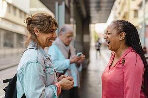 contento multirracial mujer amigos hablando mientras esperando a el autobús estación foto