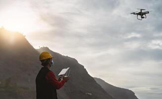 Male engineer doing inspection using drone while wearing face mask to avoid corona virus spreading - Technology and industrial concept photo