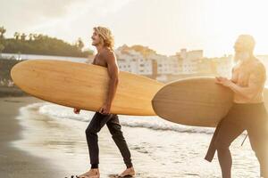 contento amigos con diferente años surf juntos - deportivo personas teniendo divertido durante vacaciones navegar día - extremo deporte estilo de vida concepto foto