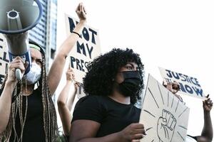 Activist movement protesting against racism and fighting for equality - Demonstrators from different cultures and race protest on street for equal rights - Black lives matter protests city concept photo