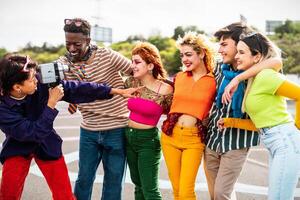 contento joven diverso amigos teniendo divertido con antiguo Clásico vídeo cámara al aire libre - juventud personas milenario Generacion concepto foto