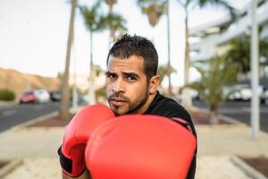 Young Latin man doing boxing exercises session outdoor - Health fitness and workout concept photo