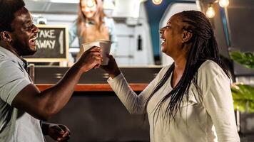 Happy African family having fun toasting with beer in a street food truck market outdoor photo