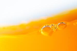 Close up bright orange juice splash texture for health and nature waves, Beautiful waves curve and little bubbles smooth for garphic design and background photo