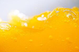 Close up bright orange juice splash texture for health and nature waves, Beautiful waves curve and little bubbles smooth for garphic design and background photo