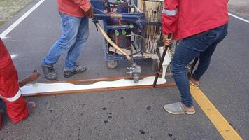 Low section of Road Worker using Thermoplastic Marking Machine photo