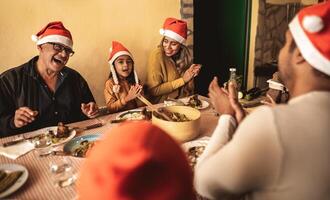 Happy Latin family having fun celebrating Christmas holidays while dining together at home photo