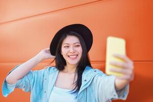 contento asiático niña tomando selfie con móvil inteligente teléfono al aire libre - de moda hombre de influencia teniendo divertido con nuevo tendencias social redes aplicaciones - milenario Generacion estilo de vida personas fanático tecnología foto