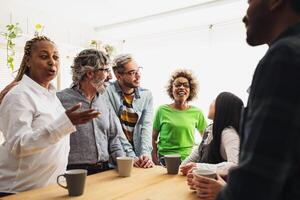 Happy multiracial coworkers with different ages and ethnicities having a break during work time photo