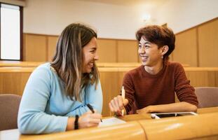 Young multiracial friends studying inside university classroom  - School education concept photo