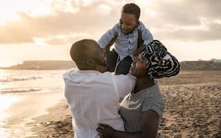 contento africano familia teniendo divertido en el playa durante verano Días festivos - padres amor concepto foto