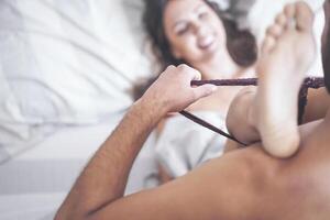 Boyfriend putting off his girlfriend's panties before having sex on bed - Passionate couple having sexy and intimate moments in the bedroom - People relationship, romance love and sexual concept photo