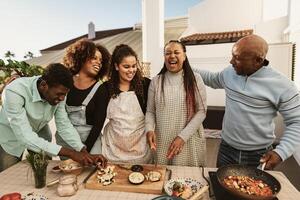 Happy African family preparing food recipe together on house patio photo