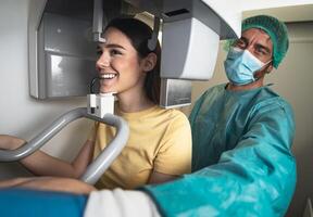 Young woman patient standing in x-ray machine - Dentist doing panoramic dental radiography - Healthcare concept photo