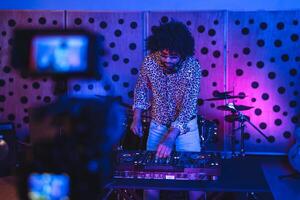 DJ jugando música con mezclador jugador en casa estudio mientras rodaje vídeo con cámara - juventud músico entretenimiento concepto foto