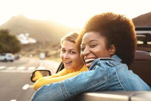 Happy girls doing road trip in tropical city - Travel people having fun driving in trendy convertible car discovering new places - Friendship and youth girlfriends vacation lifestyle concept photo